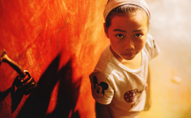 small child beside a red door