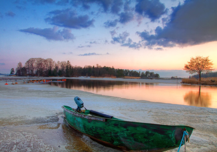 old green motor boat on shore