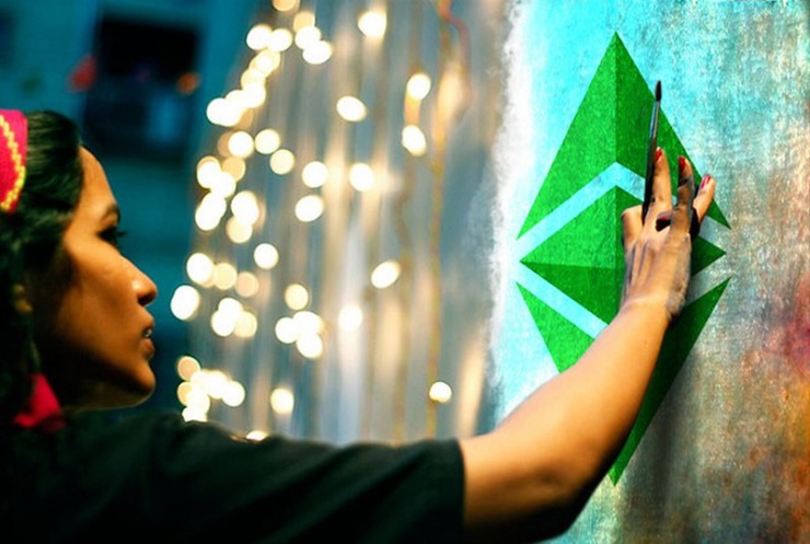 woman painting bitcoin on wall