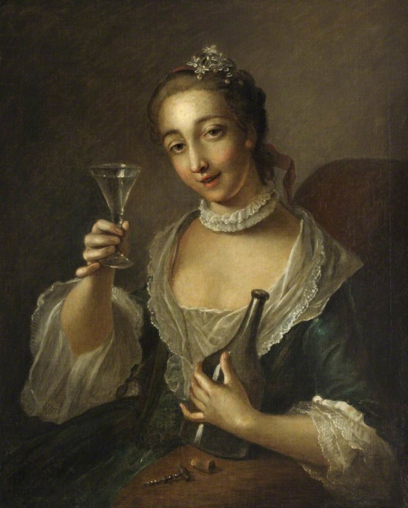 woman holds wine bottle and a wine glass in her hand.