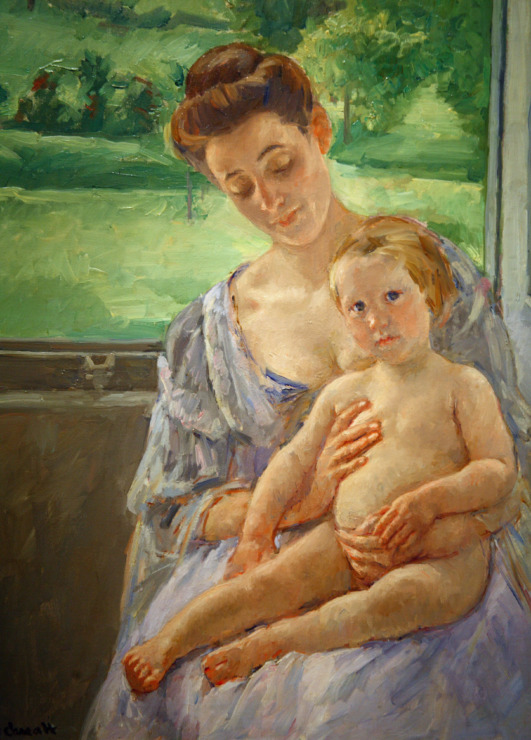 woman cradles her child in the window 