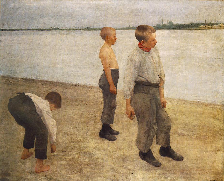 boys stand on the shore tossing pebbles into the water 