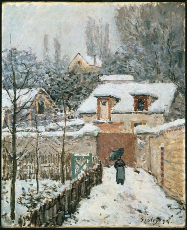 lady walks in the snow in a village 